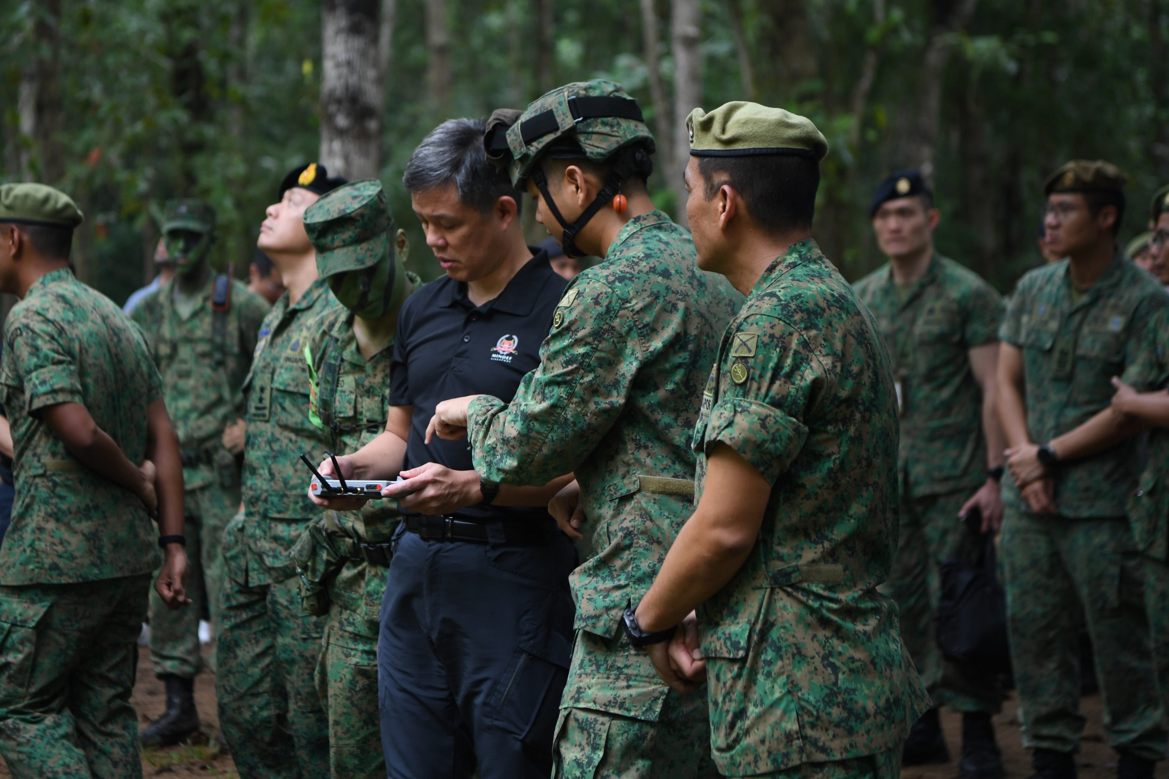 Mr Chan handling a tactical surveillance drone (Vesper) during his visit to the recruits' outfield training.